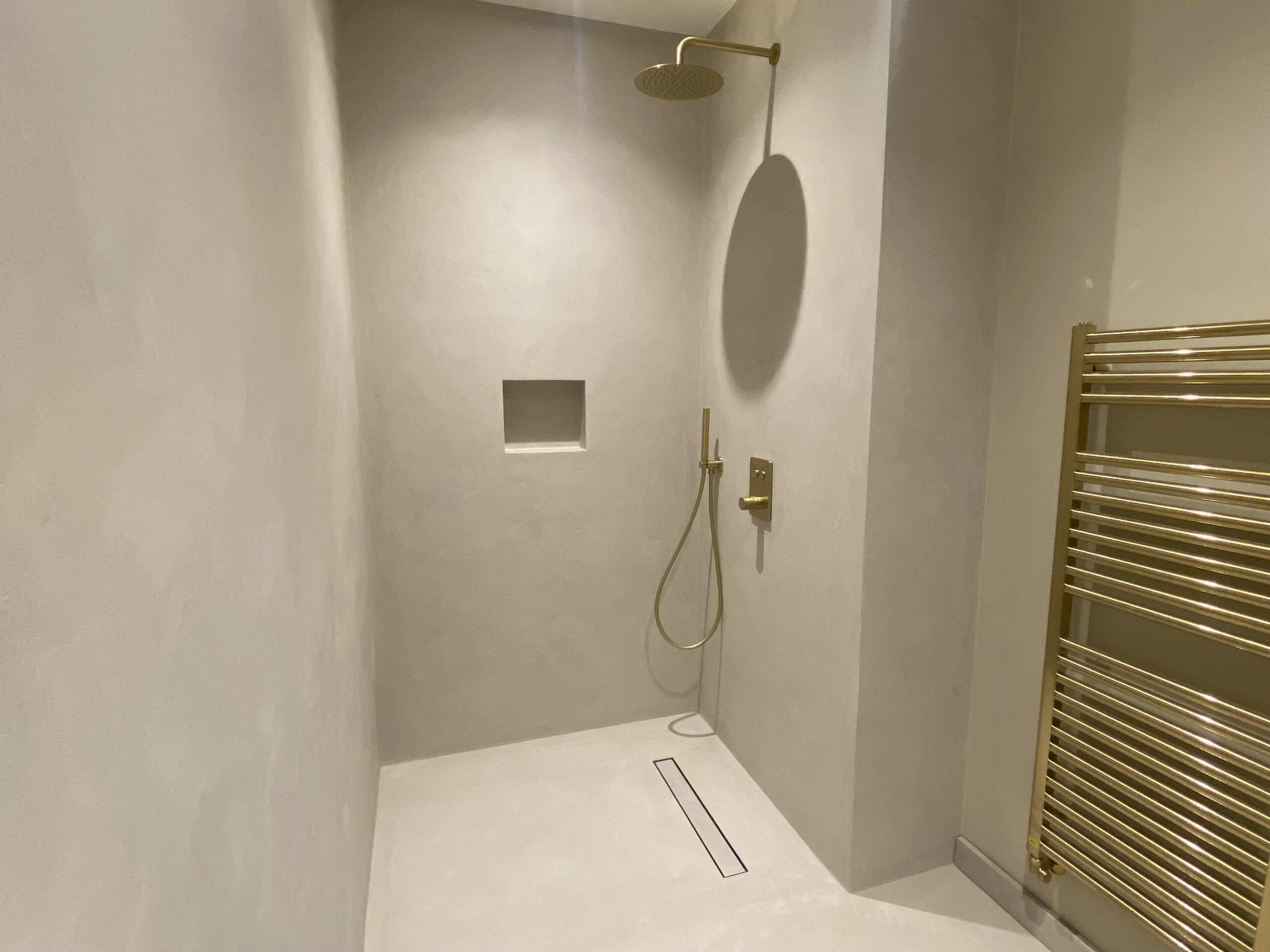 نمایش میکروسمنت در دوش walk-in با سطوح صاف و بدون درز