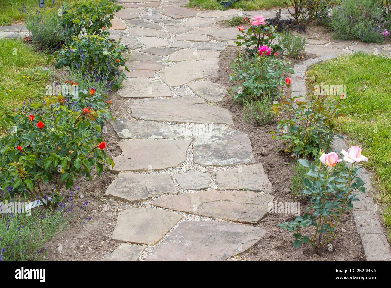 مسیر سنگفرش با گلهای رنگارنگ در کنار آن برای ایجاد ترکیب زیبا در باغ ویلا